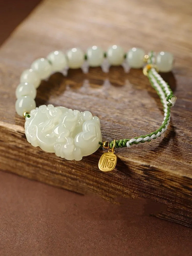 Year of the Rabbit Hetian jade charm bracelet with S925 silver detailing on a red cotton rope.