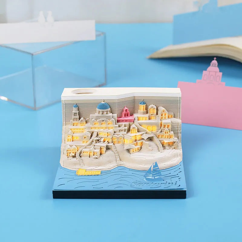 Illuminated 3D paper carving model of Santorini beach with integrated notepad