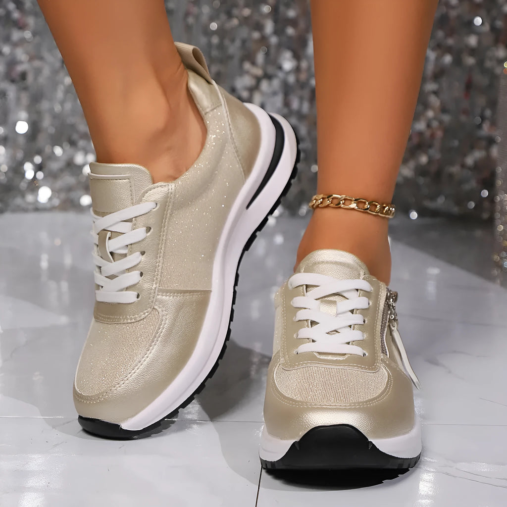 Gold women's flat sole lace-up pumps with round toe on a white background.