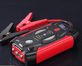 Red portable car battery jump starter power bank with digital display and jumper cables