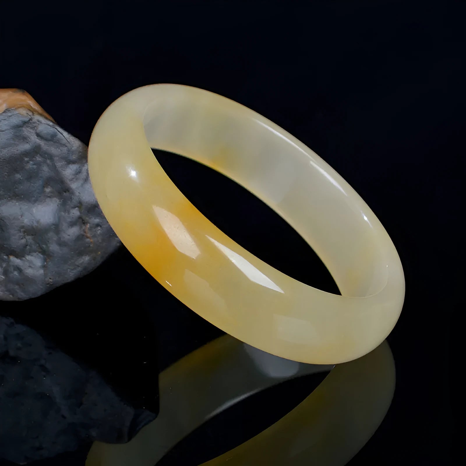 A polished natural light jade bracelet in a traditional Chinese style for women.