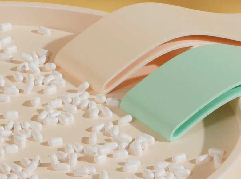 Set of four plastic elastic resistance bands in pink, orange, beige, and green colours, representing different strength levels.