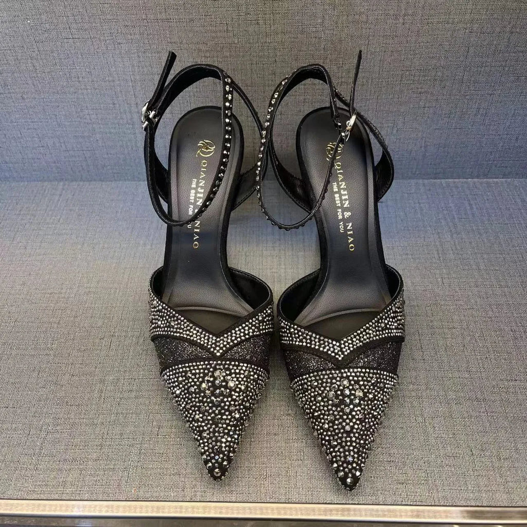 Women's black pointed toe stiletto heels with a hollow design and red sole.