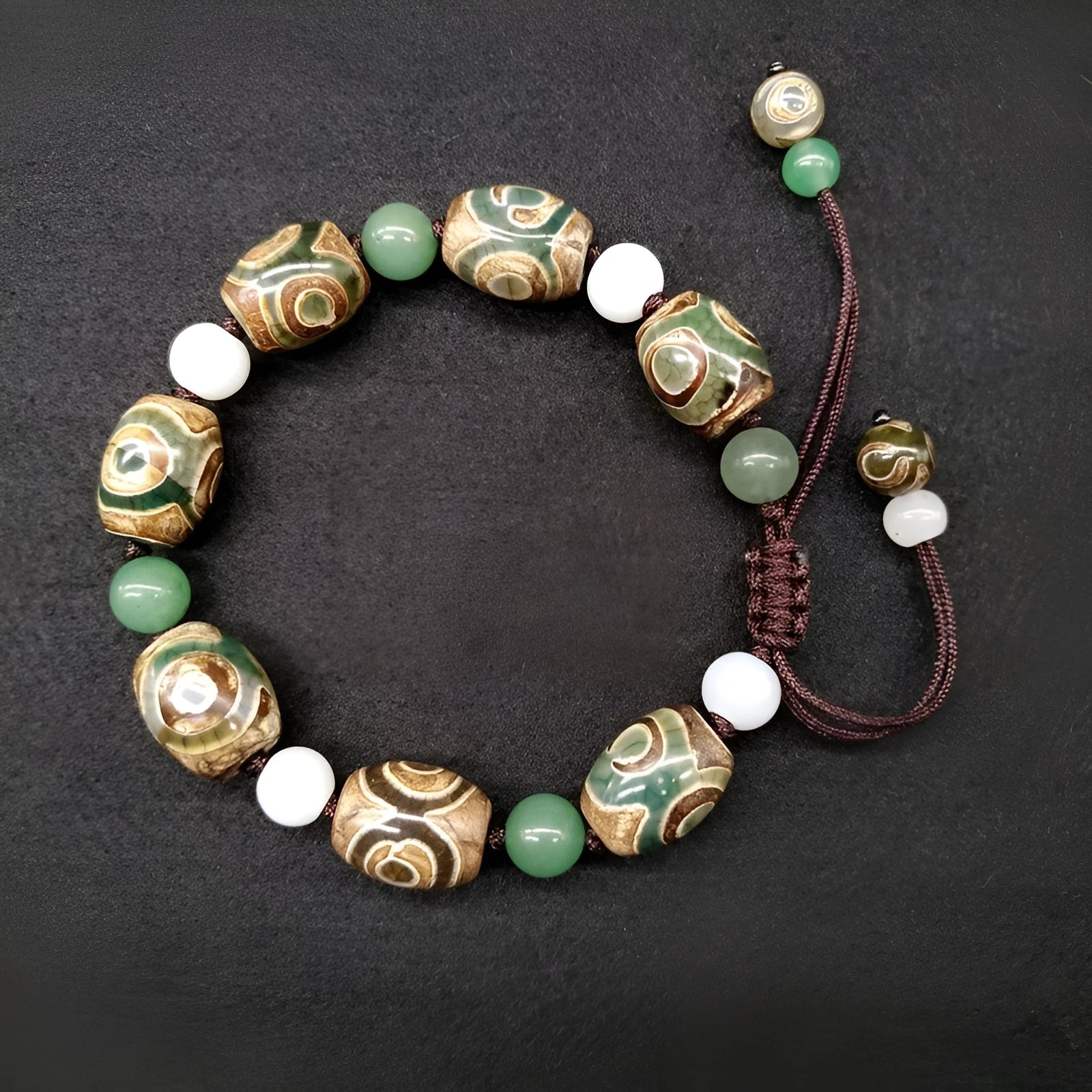 Green agate ethnic bracelet with hand-woven beads showing geometric patterns and three-eye design details