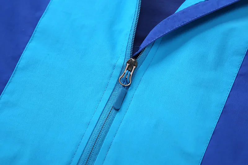 Blue lightweight boys' jacket with long sleeves and a zip, shown on a hanger.