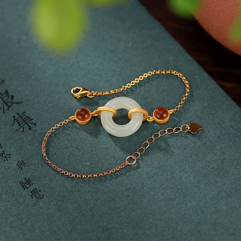 Gold-coloured women's bracelet with inlaid green Hetian jade stone and an adjustable peace buckle clasp.