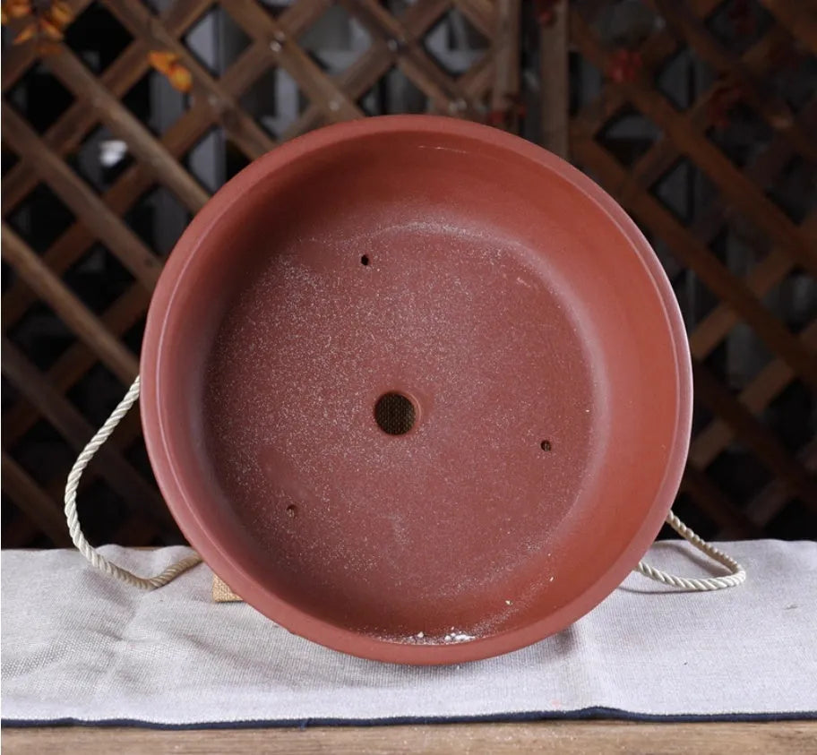 Chinese style indoor tabletop drum nail purple clay ceramic flowerpot with breathable design in purple clay colour on a wooden surface
