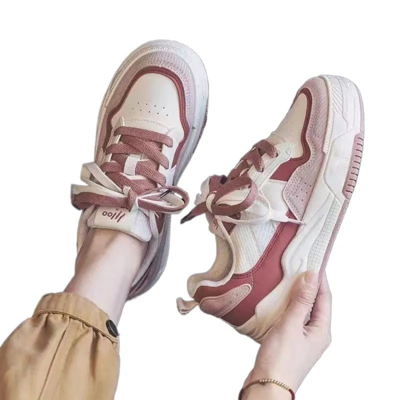 Women's pink low-top sneaker with imitation leather upper and rubber sole on a plain background.
