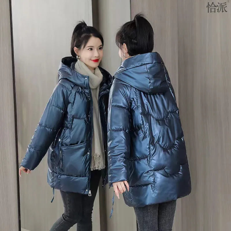 Green loose-fit hooded women's winter jacket on a hanger, showing long sleeves.