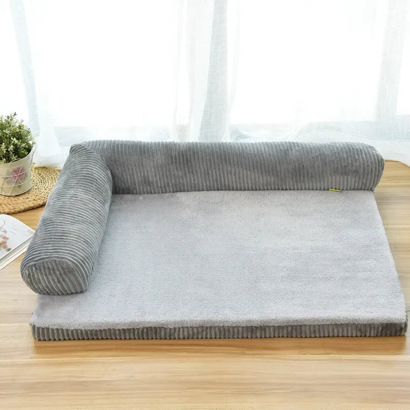 A large grey corduroy dog sofa bed with bilateral sides and a non-slip base on a wooden floor.