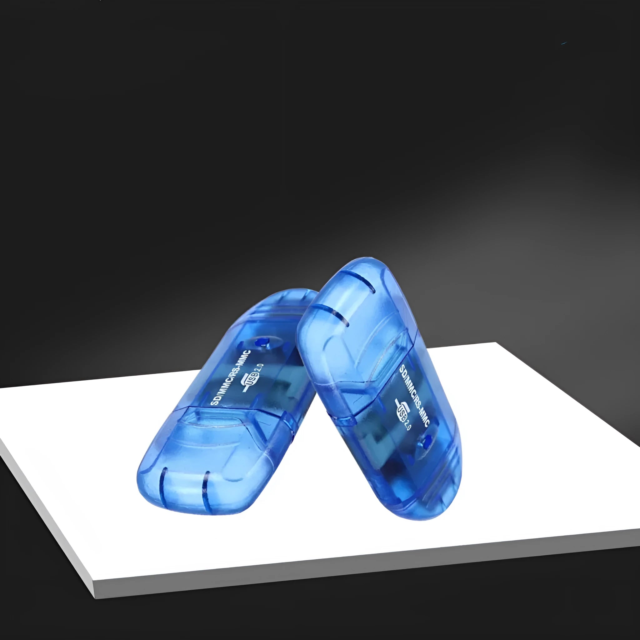 Transparent plastic USB card reader with optional LED light on a desk.