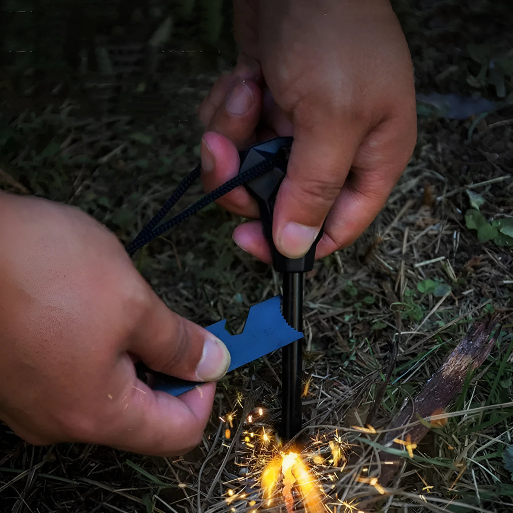 Black outdoor multifunctional survival flint tool with stainless steel scraper on a dark background.