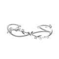 Close-up of a white gold coloured twisted branch sprout design bracelet on a wrist.