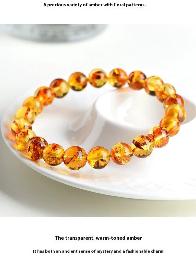 Natural yellow piebald amber geometric bracelet on a wrist, showing polished beads with flower spot patterning.