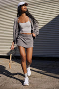 Women's blue hooded jacket and matching miniskirt two-piece street style outfit.