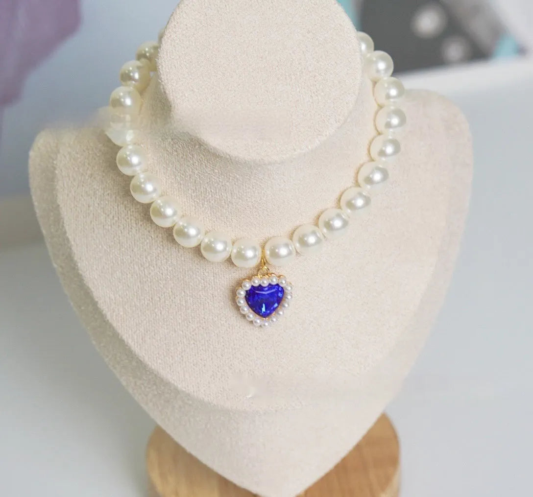 Cat collar with plastic heart charm in blue, shown alongside pink, green, purple, transparent and sapphire blue colour options