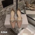 Women's black pointed toe stiletto high heels with pearl detail on patent leather-look upper.