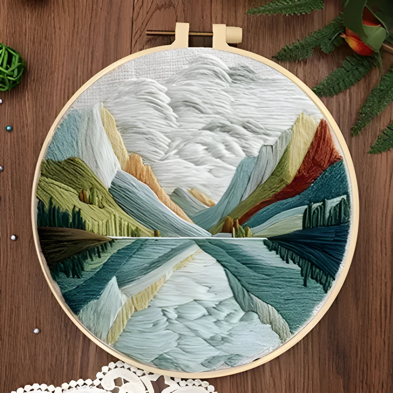 Embroidery DIY kit with cotton linen fabric, bamboo hoop, threads, and needles for landscape designs.