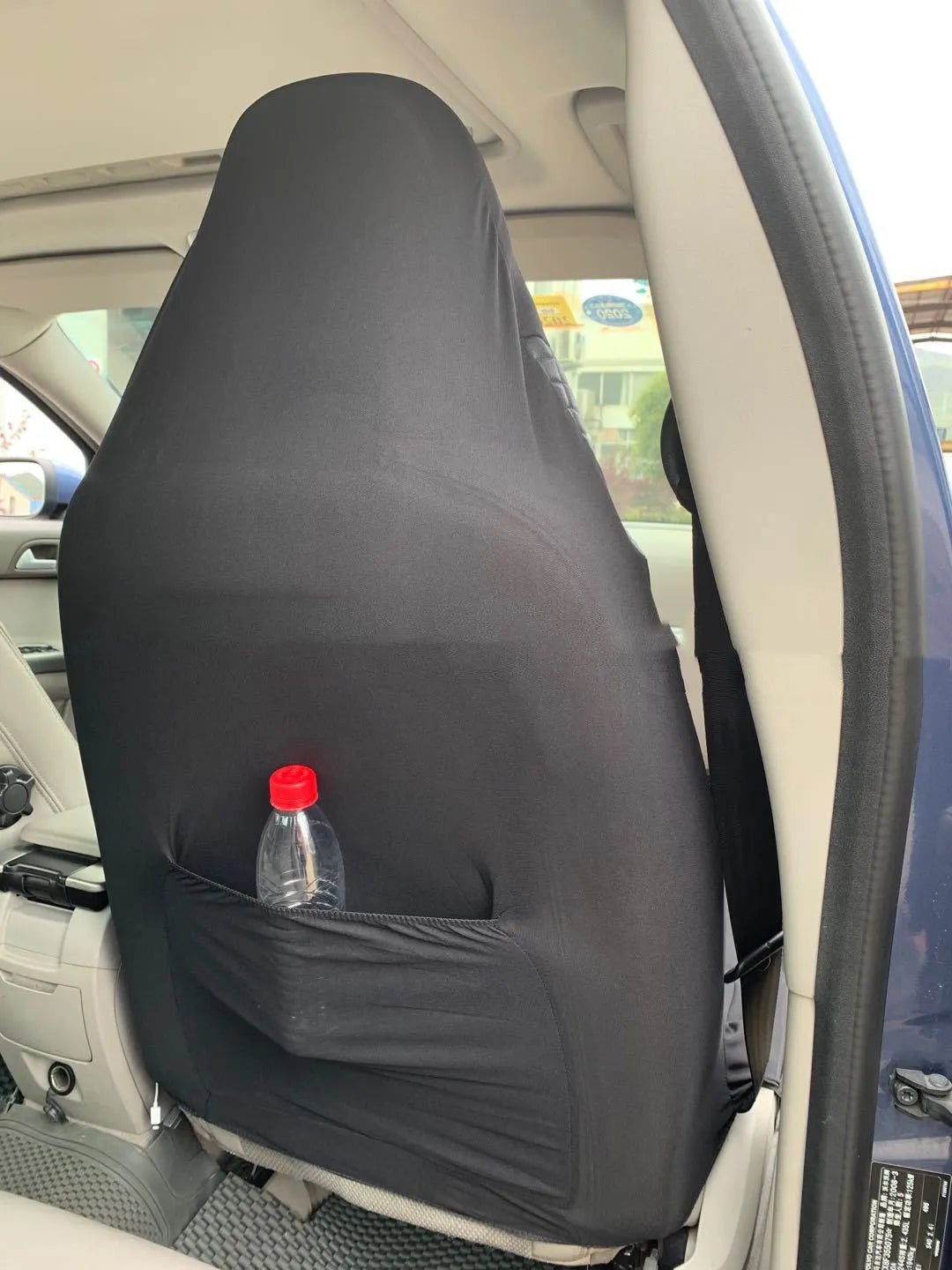 Black quilted automotive seat cover showing dimensional stitching pattern and plastic installation hooks