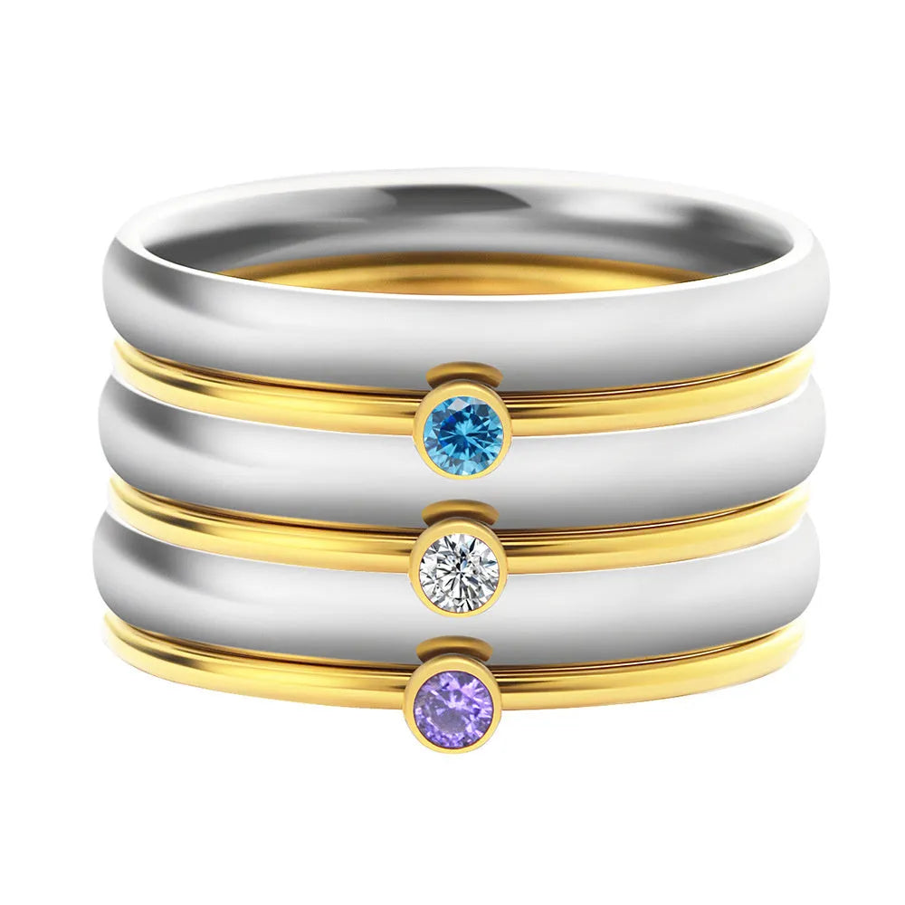 December birthstone engraved geometric ring in titanium steel with gold accents, shown on a finger.