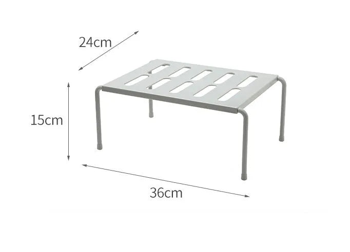 White telescopic kitchen storage rack with adjustable height on a countertop