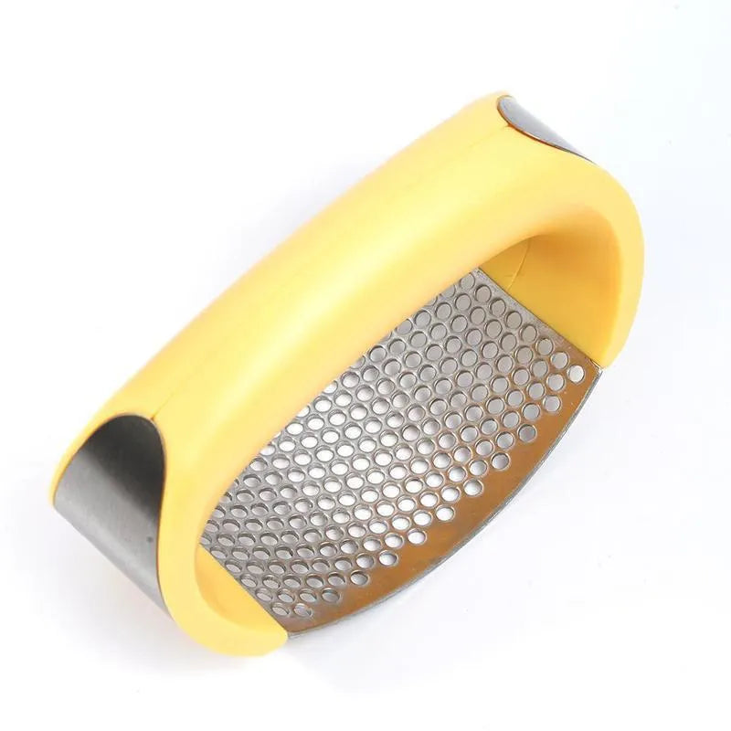 Stainless steel garlic press with ergonomic black handle on a kitchen counter.