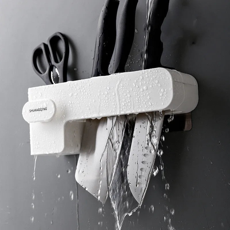 White plastic wall-mounted magnetic knife rack holding several kitchen knives