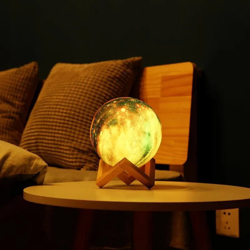 White spherical lunar night light with textured surface and glowing LED illumination on a dark surface.
