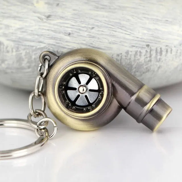 Metal whistle keychain with keyring in gold colour, front view on white background