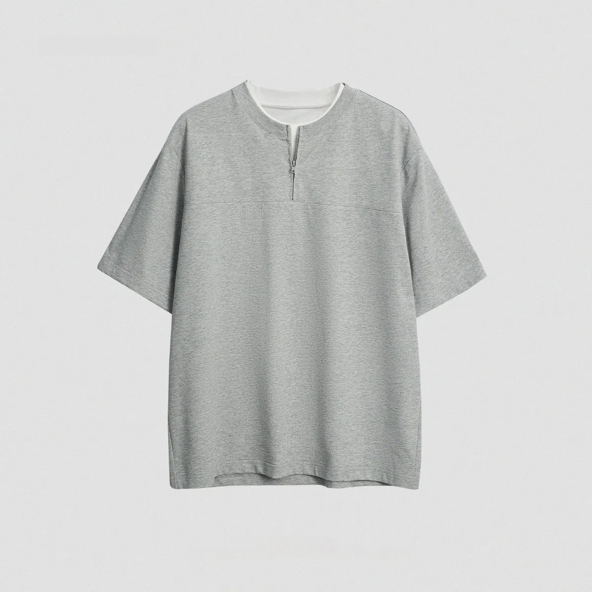 A loose blue cotton blend pullover top with a false zip and patchwork collage stitching detail.
