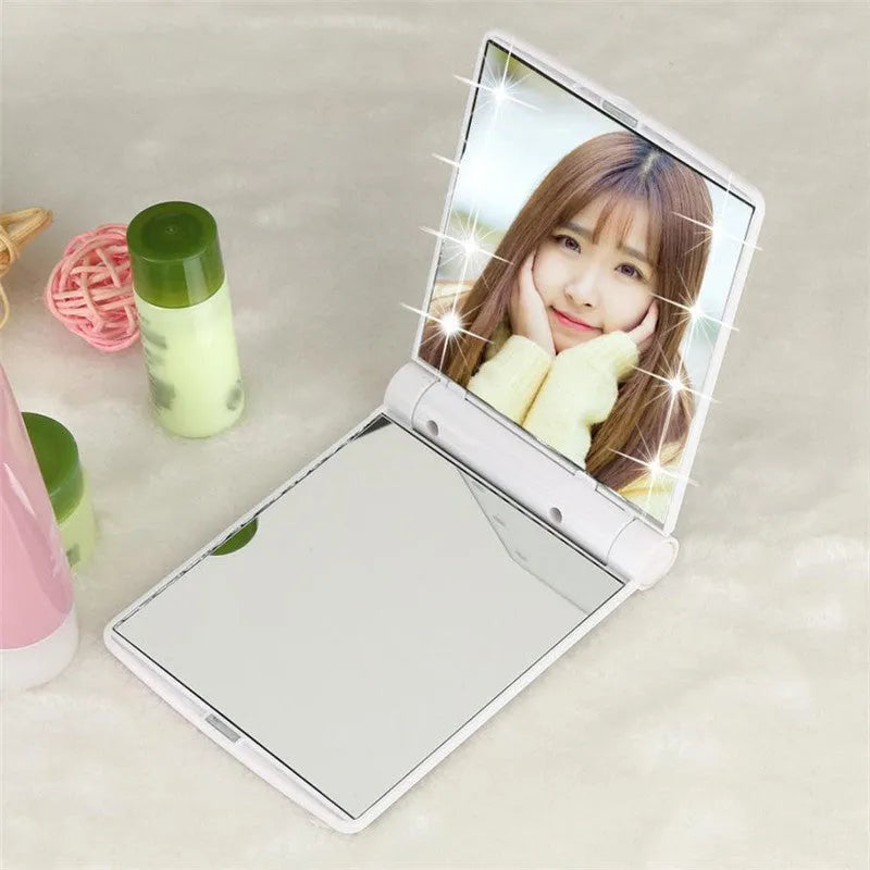 Folding LED pocket cosmetic mirror in black, blue, pink, and white, compact travel makeup mirror with built-in light.