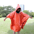 Orange PE aluminium film emergency sleeping bag folded and laid flat on outdoor ground