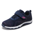 Women's low-top casual sneaker with mesh upper, wedge heel, and Velcro strap fastening.