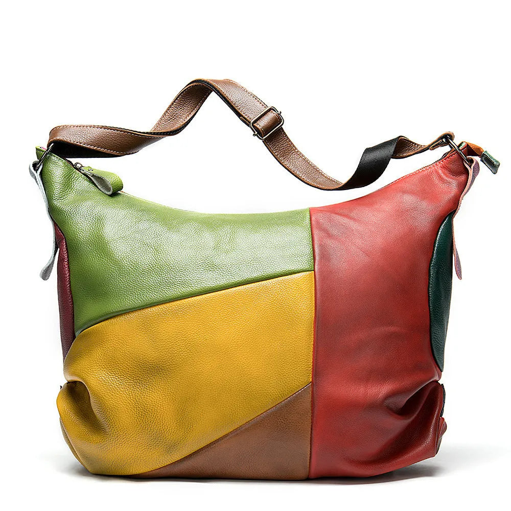Brown cowhide leather crossbody travel bag with stitching, shown holding a laptop and A4 magazine.