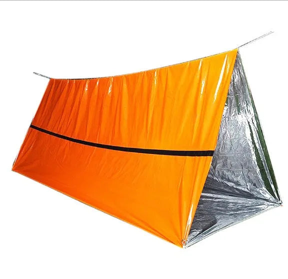Orange PE aluminium film emergency sleeping bag folded and laid flat on outdoor ground