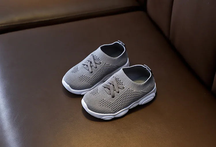 Children's lazy slip-on shoes in white, black, pink, or grey with fabric upper and rubber sole.