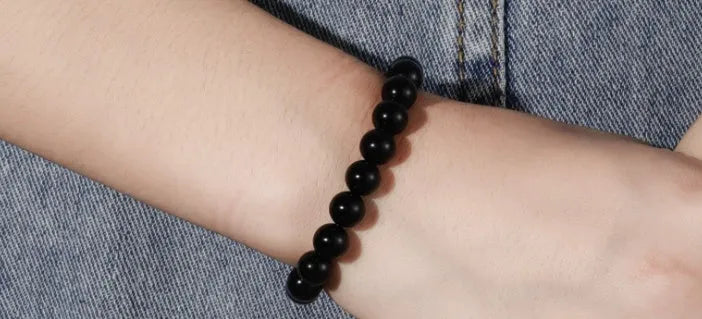 Black agate geometric bracelet with 8mm beads on a black elastic cord.