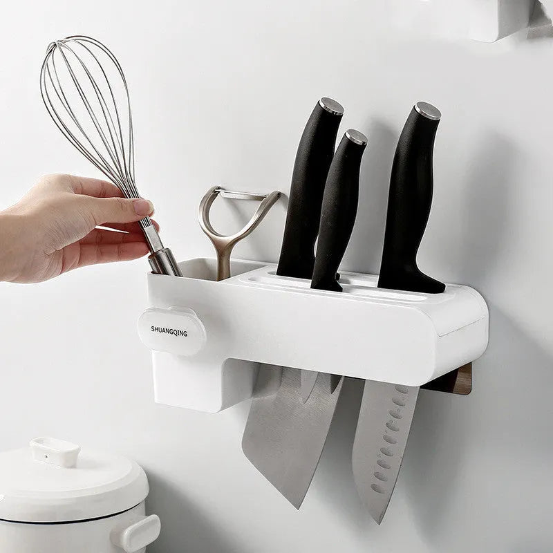 White plastic wall-mounted magnetic knife rack holding several kitchen knives