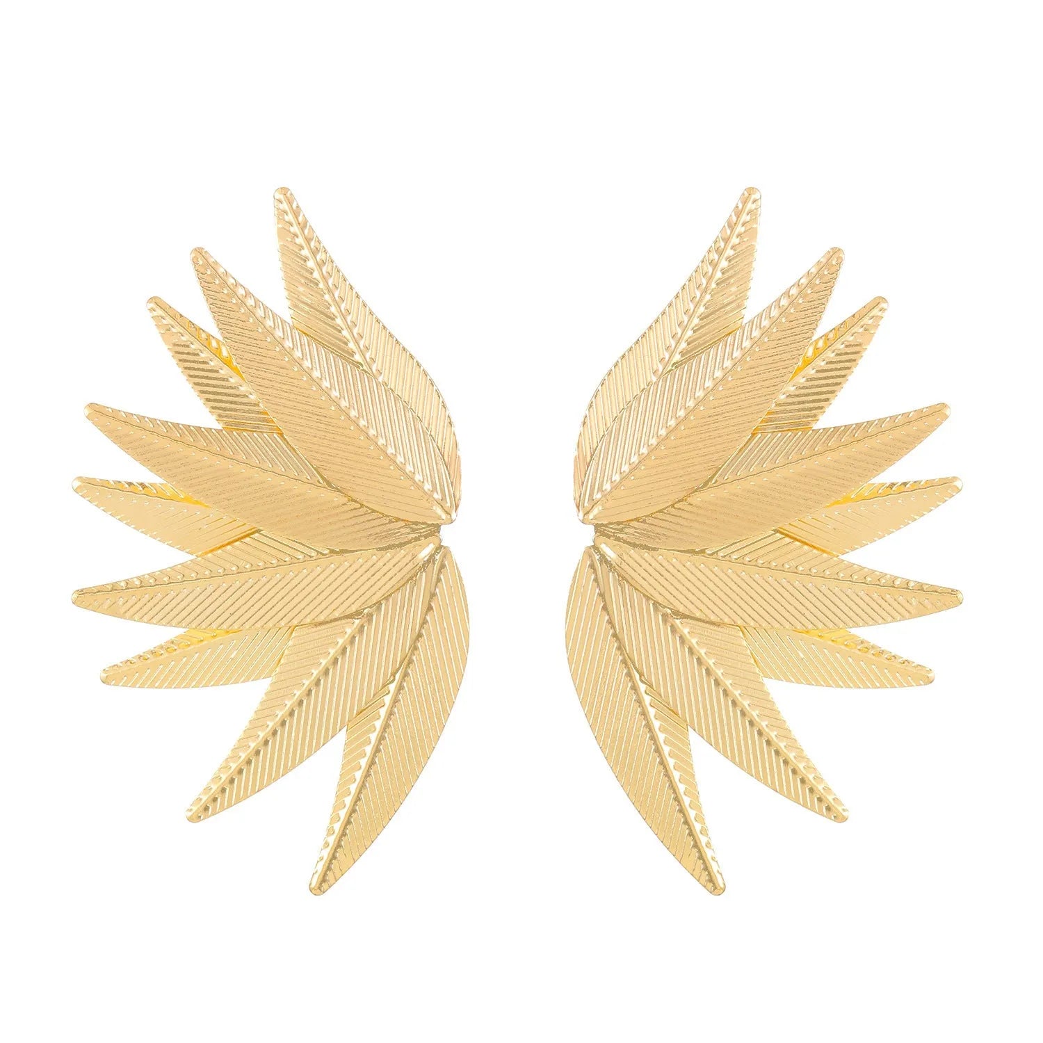 A pair of gold alloy drop earrings shaped like leaves, lying on a surface.