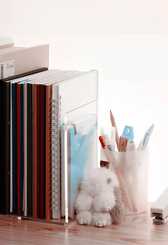 Clear transparent acrylic bookshelf displaying books on desk with smooth edges and minimalist design