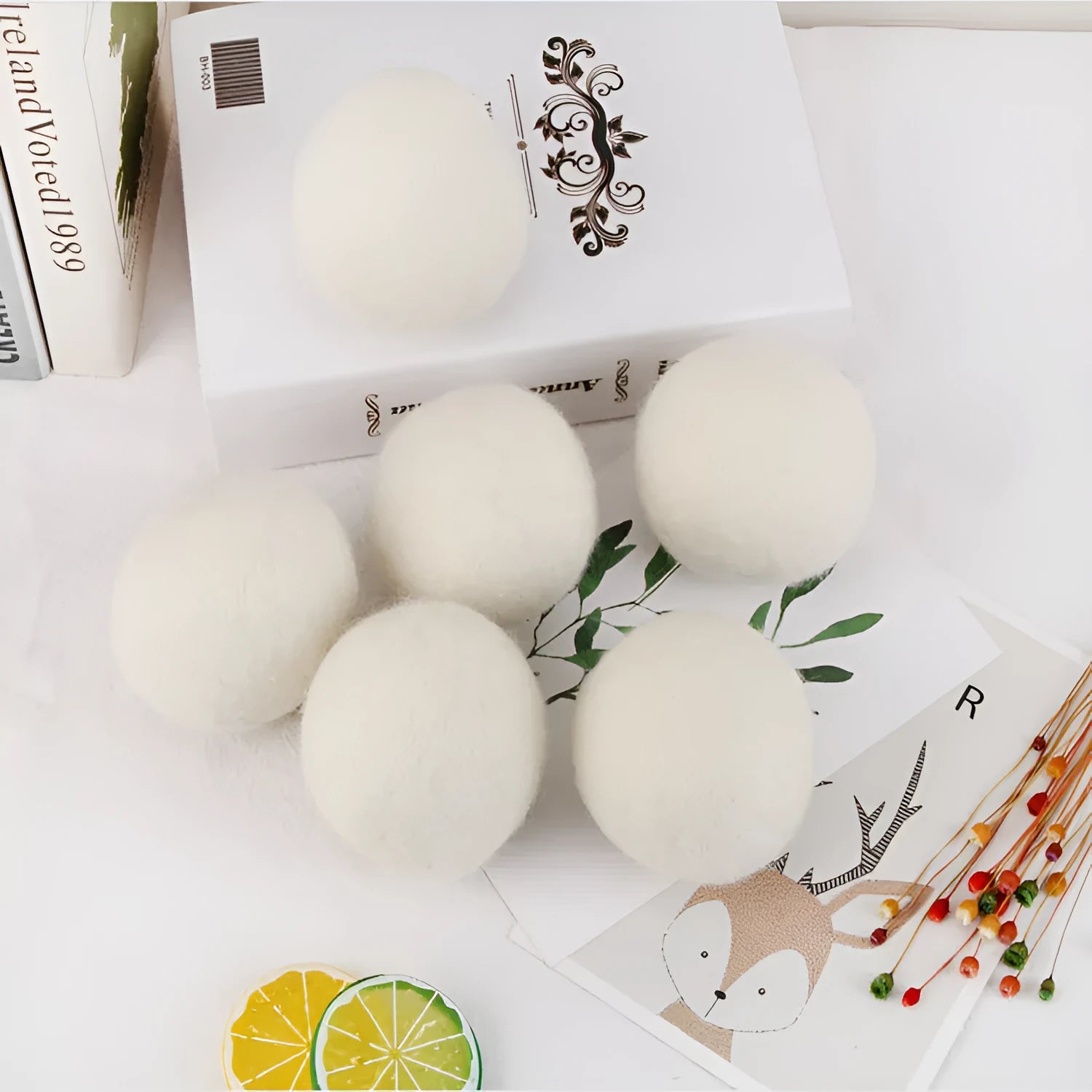 Handmade natural wool felt drying ball for laundry next to a plain cotton storage bag.