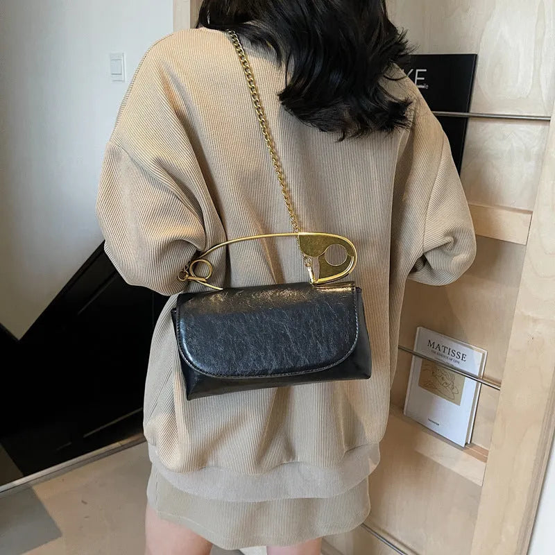 Creative Personality PU paper clip shoulder handbag in a horizontal square shape.