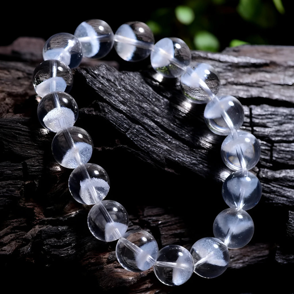 Women's white crystal pyramid bead bracelet with Ruyi design motif on a wrist.