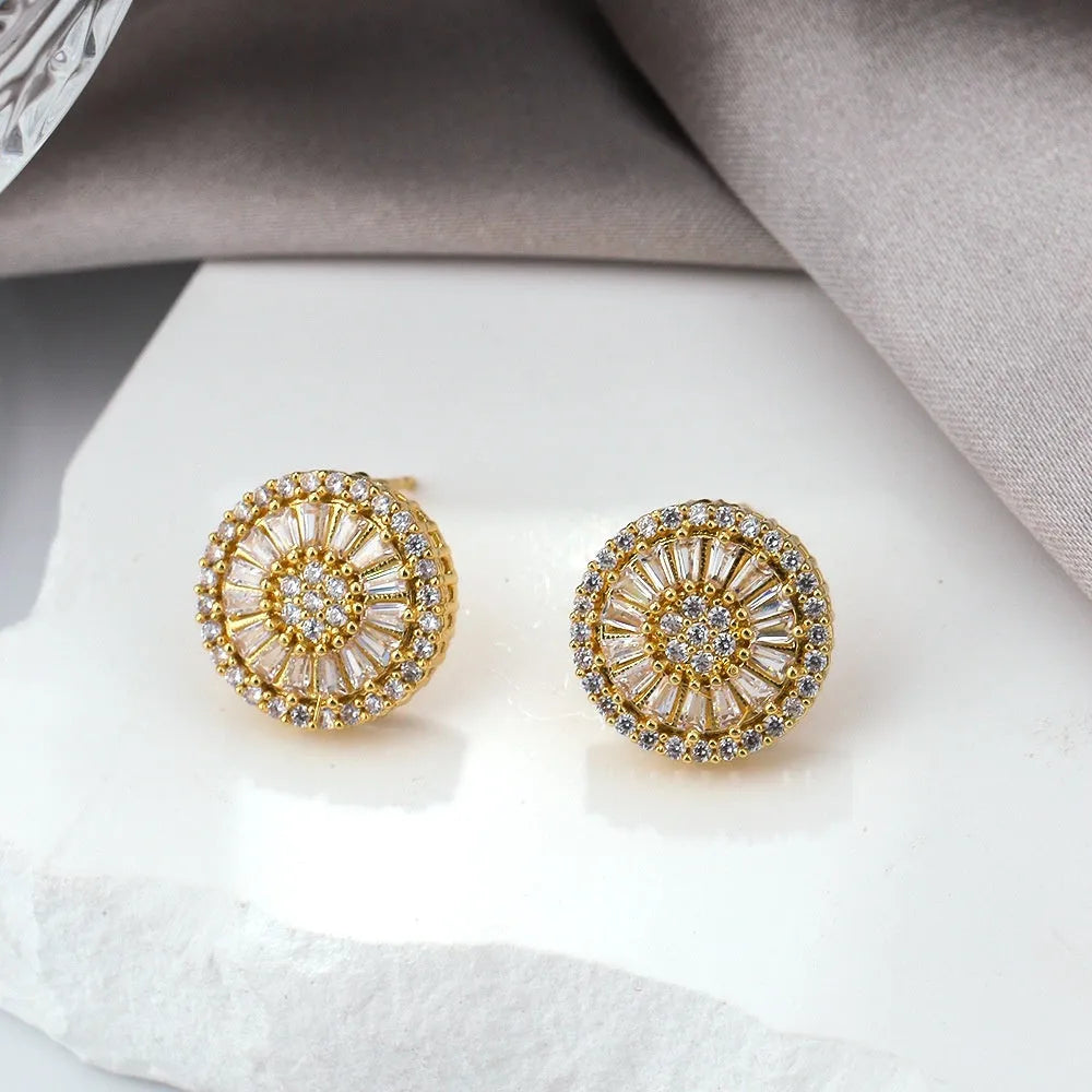 A pair of gold-coloured geometric earrings with a round pattern design, made from copper.