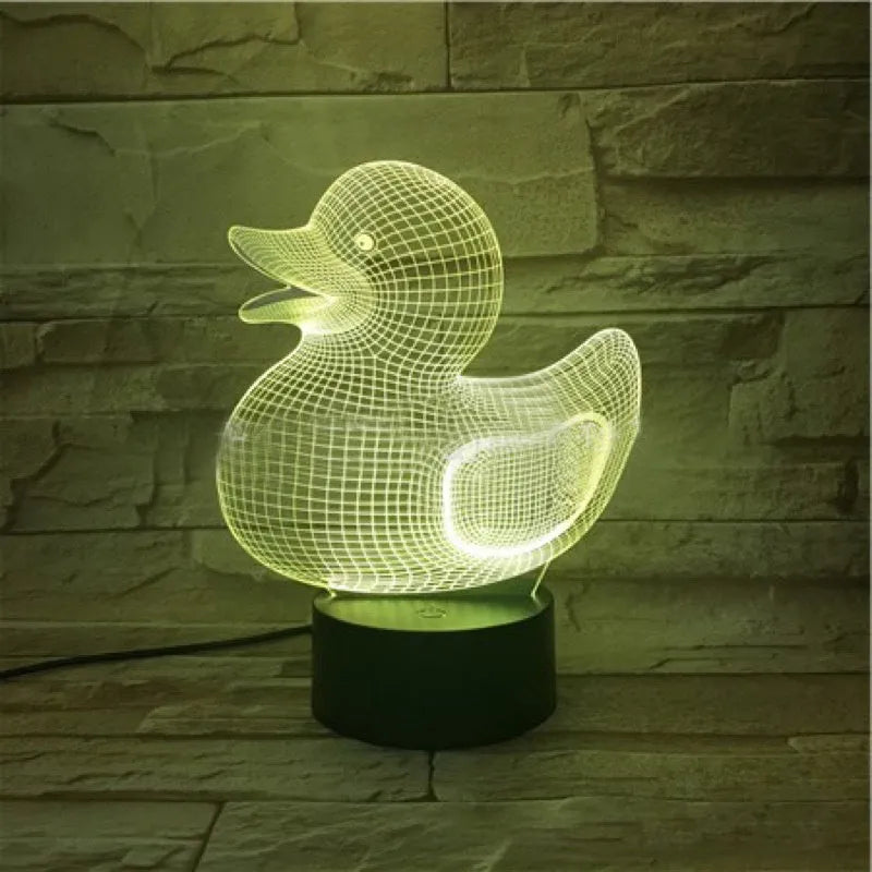 Little yellow duck 3D night light with remote control on a table, showing its colourful LED illumination.