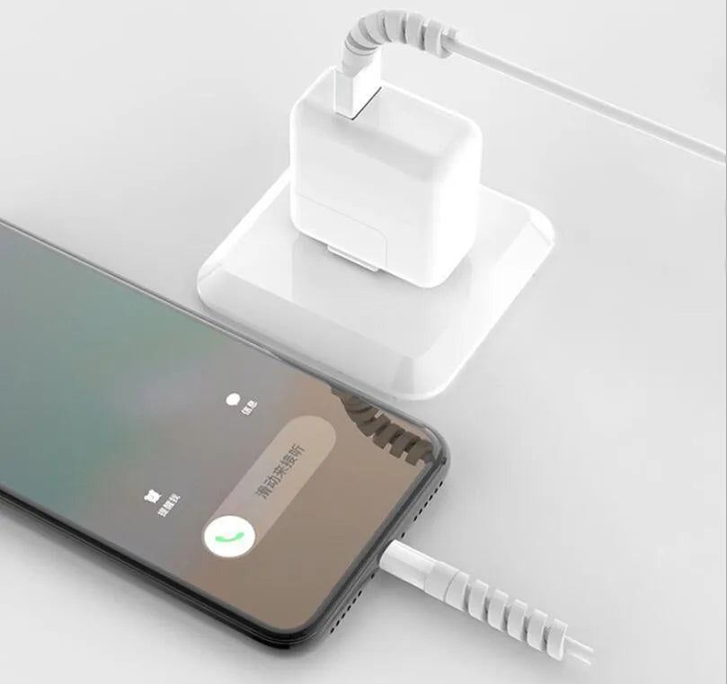 Plastic spiral charging cable protector in various colours next to a USB cable.