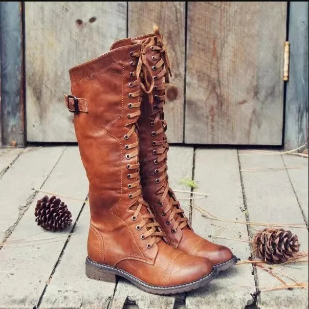 Women's black high-leg boots with a round toe and a low chunky rubber heel on a white background.