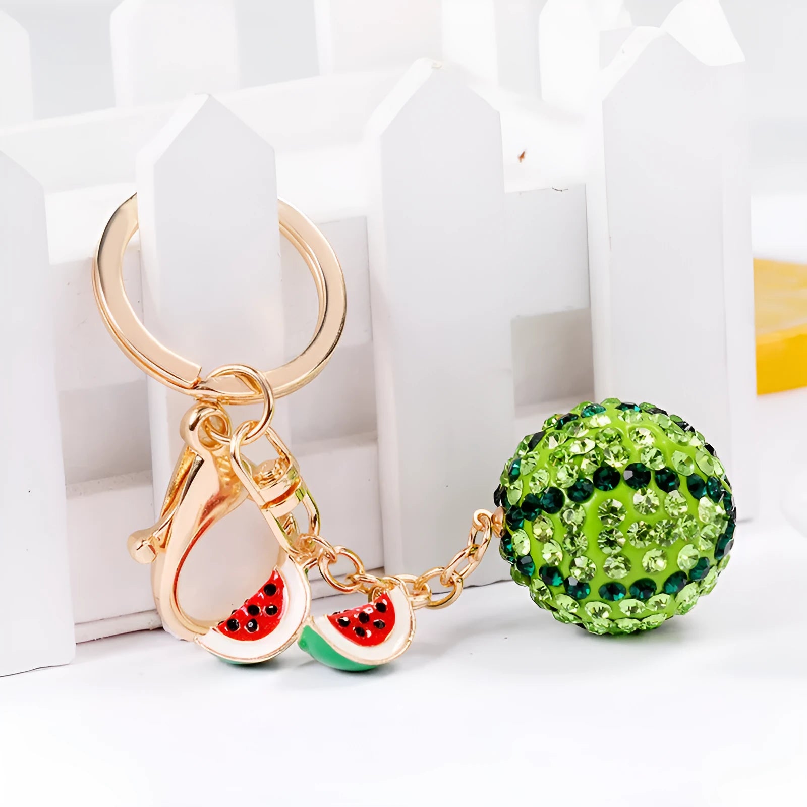Green zinc alloy watermelon keychain on a key ring, showing detailed fruit shape.
