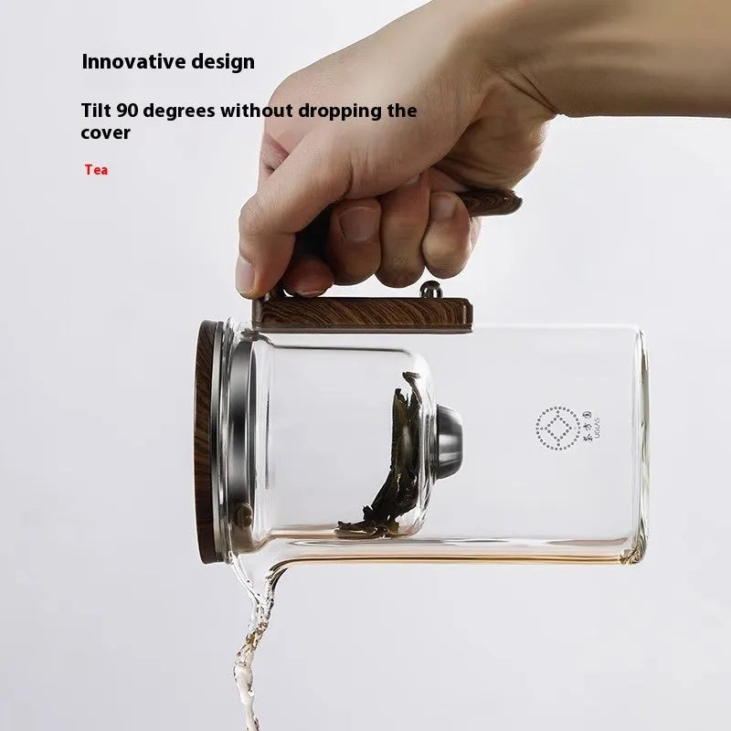 Glass teapot with wooden handle showing magnetic separation button and inner filter basket.