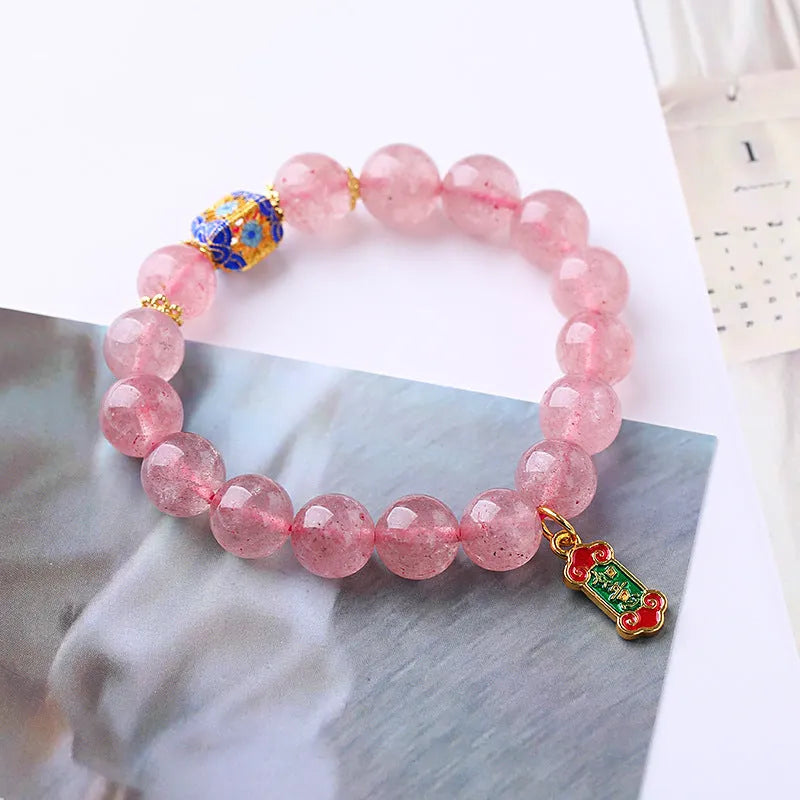Pink strawberry quartz crystal bracelet with hand-woven beads, Ruyi charm, and letter charms.